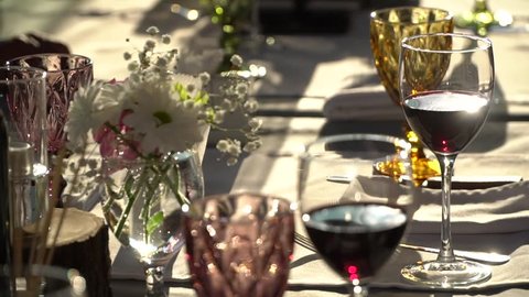 On the table are glasses of wine, flowers. Close-up shows glasses of wine illuminated by natural sunlight.Wine tasting.