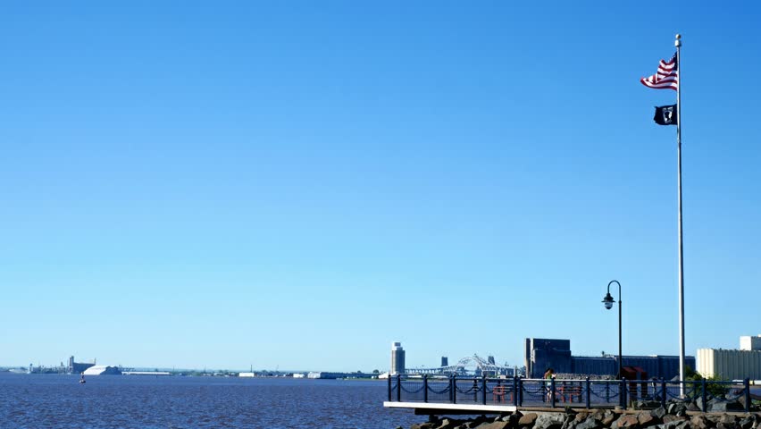 The shipping harbor in Duluth Minnesota during a sunny morning along the shores of Lake Superior with people taking selfies.