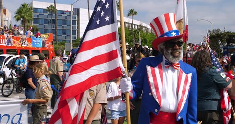 LOS ANGELES, CALIFORNIA, USA - JULY 4, 2018: Afro-American black man dressed as Uncle Sam cheering people at annual Independence Day celebration parade in Santa Monica, Los Angeles, California, 4K