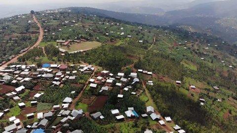 Aerial drone footage of a village in Rwanda. Gorgeous green hills and mountains, rural village with red roofs and brown clay streets. Rwanda is one of the most beautiful countries in Africa.