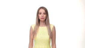 Young serious woman standing isolated over yellow background while looking camera says no