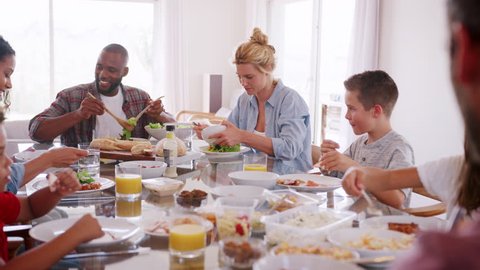 Two Families Enjoying Meal At Home Together Shot In Slow Motion