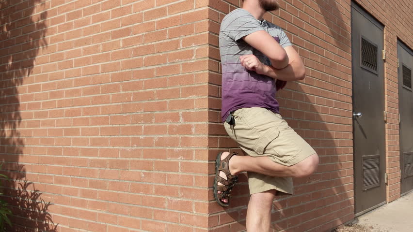 4K Vintage City Brick Storage Shed with Caucasian Male Leaning Against Wall