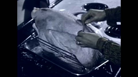 CIRCA 1950s A housewife cooks a turkey in her Frigidaire oven.