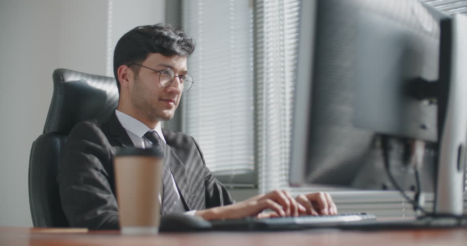 young iranian businessman working at computer in office, then celebtating successful business deal. business, victory concept 4k