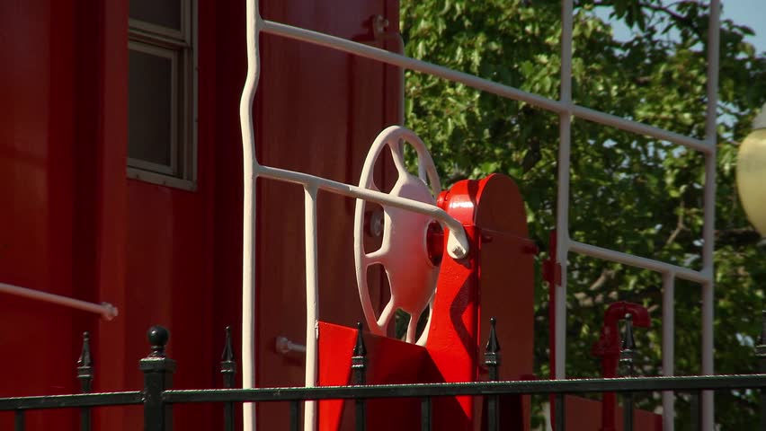 An old train Caboose stands on display in a park at the old railroad depot in a small Midwestern town.