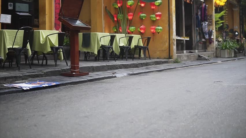 Hoi An, Vietnam - May 10, 2018: Rickshaw drive the chinese tourists along the ancient street in old town in Hoian. Historical UNESCO destination. Wheels closeup by sliding cam.