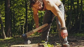 strong muscular man splitting firewood with an axe