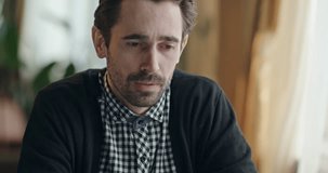 Miserable upset man sitting crying at a table