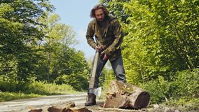Strong muscular man splitting wood with an axe