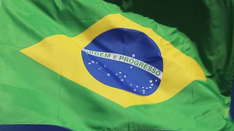 Brazilian national flag waving in wind front of blue sky. Flag of Brazil natural video.