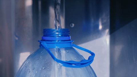 Water is poured into a plastic bottle.