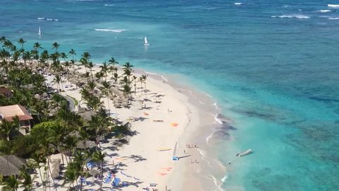 Dominican Republic Punta Cana sunny sandy beach, palm trees and white sand beach. Sunny day top view island. White sand beach and sea. Summer morning over sea in Atlantic ocean landscape. Paradise sea