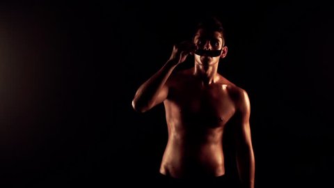 Sexy man dancing on black background