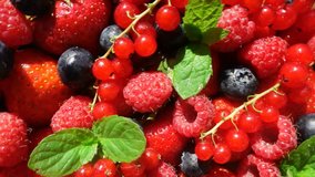Red ripe garden strawberry and blueberry, rotation of berries on white table, beautiful background, video loop