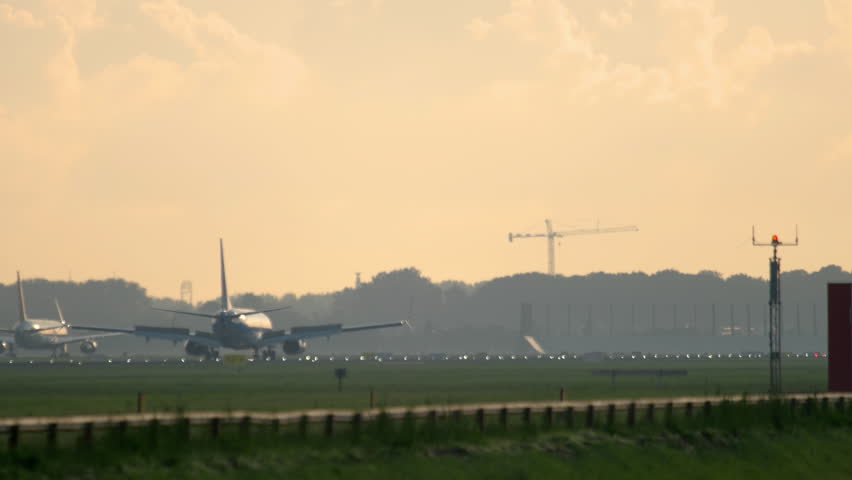 Airplane braking after landing at runway 06 at sunrise. Airport of Amsterdam, Holland