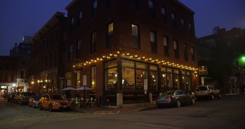 PORTLAND, MAINE - Circa July, 2018 - A nighttime establishing shot of a corner bar and restaurant in the tourist district of a city. 