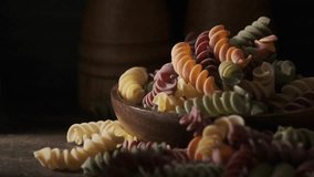 Dried colored fusilli pasta on wooden table