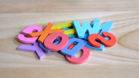 Slow motion / High Speed Video of Falling colorful letters on wood background