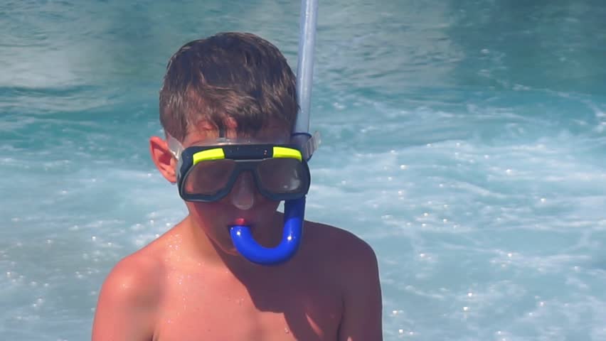 boy in a mask for swimming on the seashore