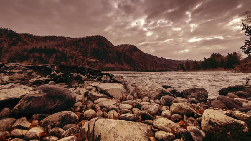 4k UHD timelapse shot of the splashing water in a river near mountain forest. Huge rocks and fast clouds movenings. Horizontal movement on motorised slider dolly.