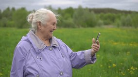 adult woman with gray hair laughs, looking at the phone.