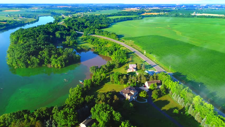 Scenic Wisconsin rural landscape with fog and white pelicans flying, aerial flyover.
