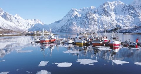 Aerial panorama drone view of beautiful Lofoten Islands winter scenery with traditional fishing boats lying in harbor on a cold sunny day with scenic blue sky, Norway, Scandinavia, northern Europe