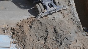Heavy mining excavator loads rock ore into a dump-body large mining truck