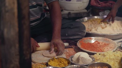 street food market in india - hands preparing spicy dough with rolling pin 