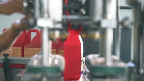 Red Bottles Arriving At A Machine Through A Productoin Line