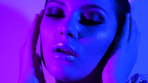 Fashion model girl in neon light, beautiful model woman with make-up, Art design of female disco dancing, posing in UV, colorful make up. Night club, Party. 4K UHD slow motion video footage