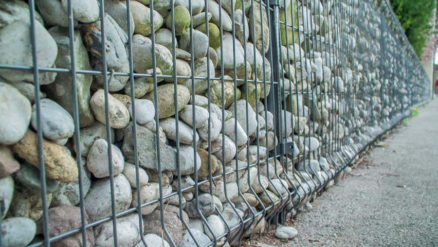 There are big stones behind a fence.
