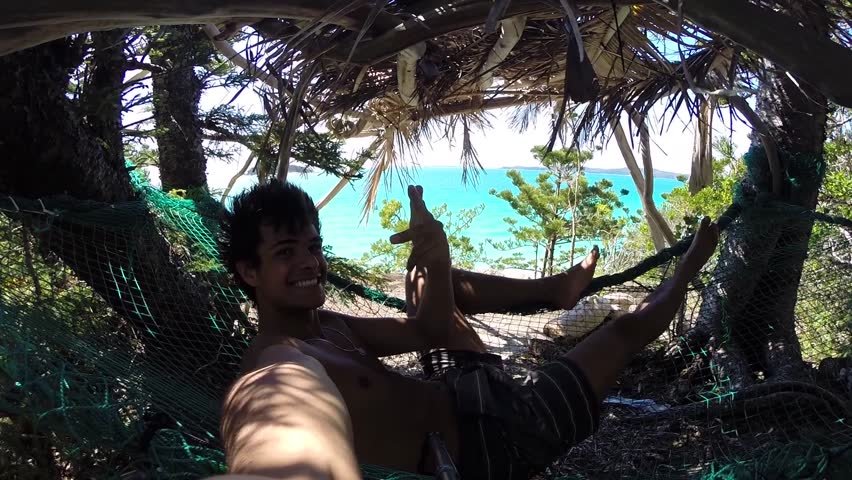 Selfie of a man smiling and chilling in a hammock in front of the ocean. Location Australia whitsundays islands