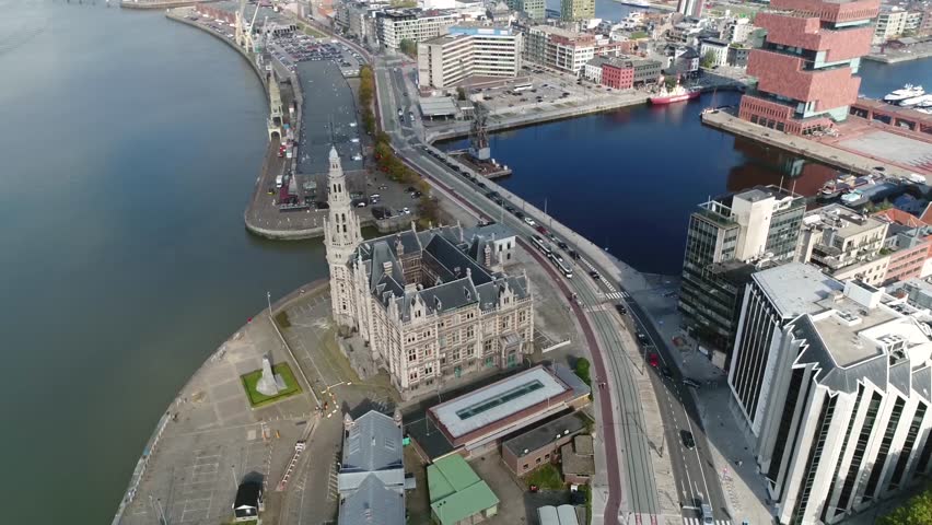Aerial footage of Belgium Antwerp classic building Loodsgebouw located in old city center Schipperskwartier also showing old steamcrane and modern buildings in background 4k high resolution footage