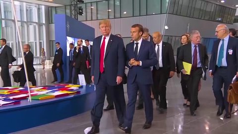 2018 - U.S. President Donald Trump moves through a crowd at the NATO summit conversing with French President Emmanuel Macron.