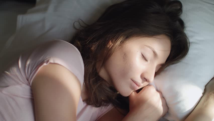 Young Beautiful Woman Wakes Up In The Morning. Sun Rays Fall On Her Face. Close Up. | Shutterstock HD Video #1014063317