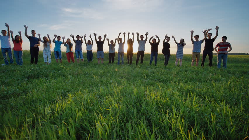 Students say goodbye to the school. Pupils waving their hands against the backdrop of the setting sun. Royalty-Free Stock Footage #1014064601