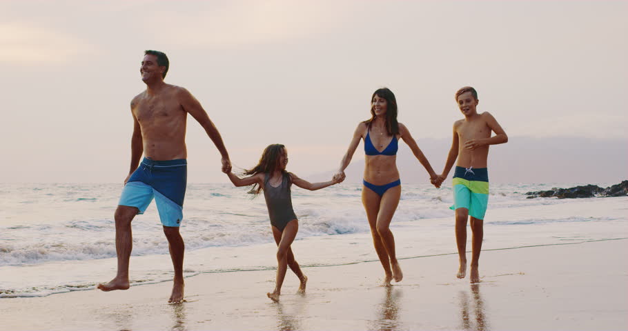 Happy young family on the beach at sunset | Shutterstock HD Video #1014066098