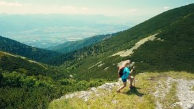 Aerial View Happiness Woman tourist walking on the top of mountain in summer sunny day under sun light. Beautiful mountains landscape view. Drone 4K Video