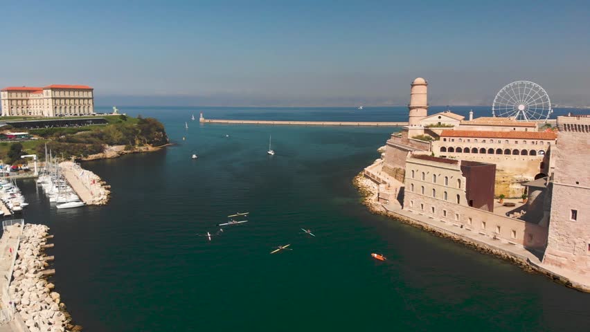 Flying out of Marseille marina to the ocean. The old port of Marseille in France exiting to the ocean with boats and cruise ships. French historic buildings in European maritime town.