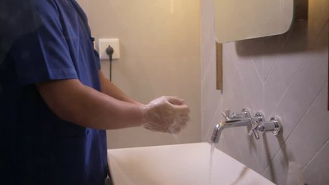 Male surgeon washes his hands carefully before the operation. Edited and raw.