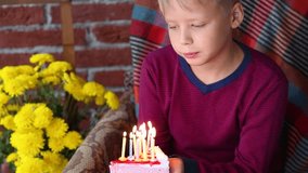 Birthday cake with 10 candles in hands of happy cute blond boy celebrating his birthday. Real time ful hd video footage.