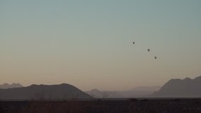 HD high quality video of hot air balloons flying above famous endless sand sea area of Sossusvlei Namib Desert red sand dunes on sunny early morning in Namib-Naulkuft Park in Namibia, southern Africa