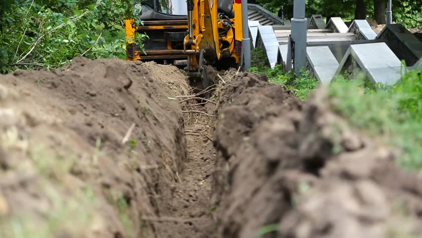 Excavator digs a trench for laying the cable Royalty-Free Stock Footage #1014116678