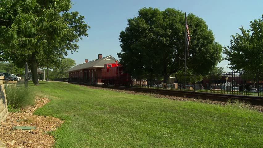 A rail road leads to a small town train depot in Lee