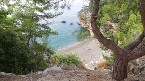 Beautiful sunrise at charming deserted rocky beach in Turkey. Top view from high rock of bright blue sea water, green plants and huge stones. Real time full hd video footage.
