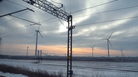 Professional video of point of view from train passing windmills at sunset in 4k slow motion 60fps