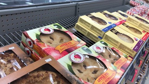 Coquitlam, BC, Canada - July 12, 2018 : Motion of woman buying apple pie inside Walmart store with 4k resolution