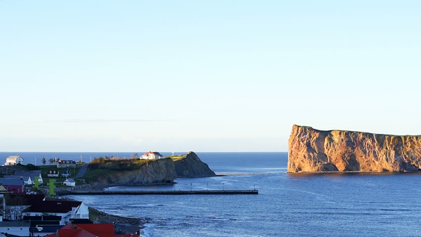 Panning of sunset view at Rocher Perce rock in Gaspe Peninsula, Quebec, Gaspesie region, Canada, Saint Lawrence gulf water, flying gannet birds, waves